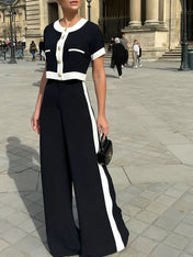 Conjunto Victoria preto com detalhes em branco, composto por blusa cropped de botões dourados e calça pantalona de cintura alta estilo alfaiataria clássica