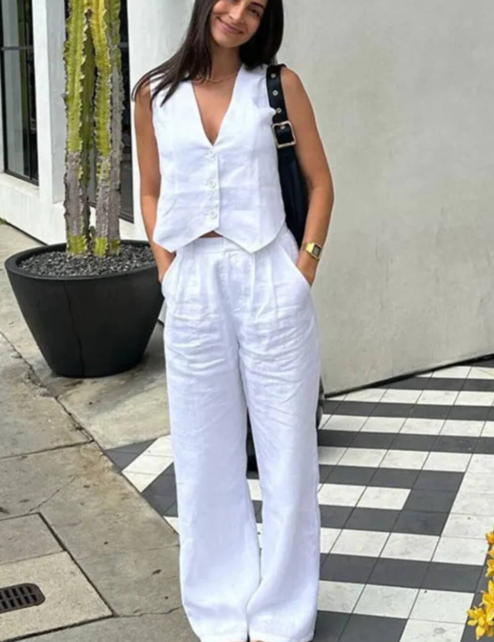 Modelo vestindo Conjunto Glover bege claro, composto por colete de alfaiataria com botões frontais e calça pantalona ampla de cintura alta