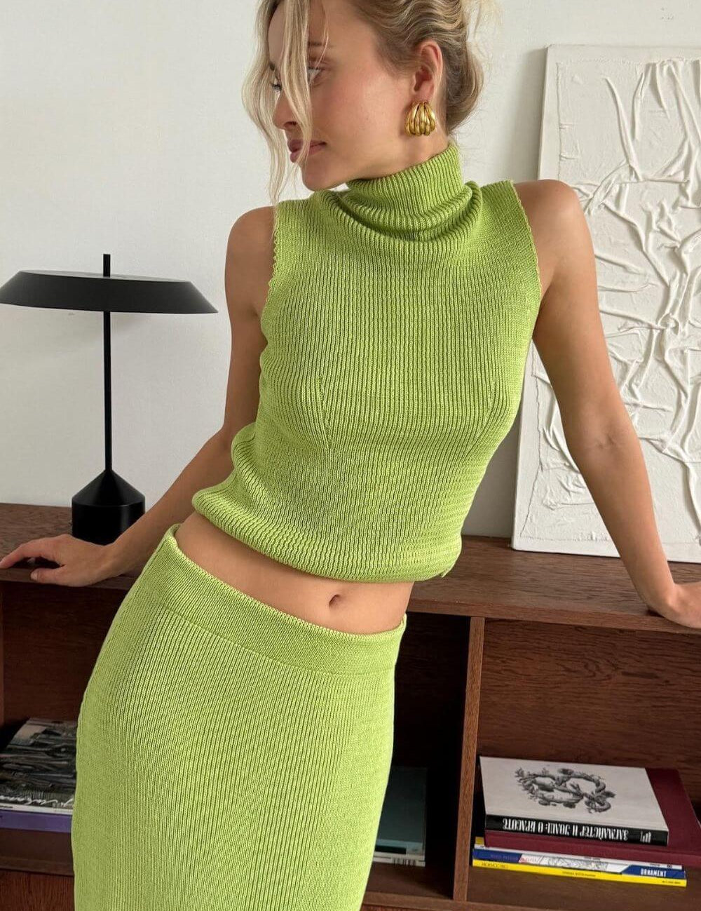 Modelo vestindo Conjunto Amaya de tricô canelado, composto por regata sem mangas de gola alta e saia longa reta, visual monocromático elegante