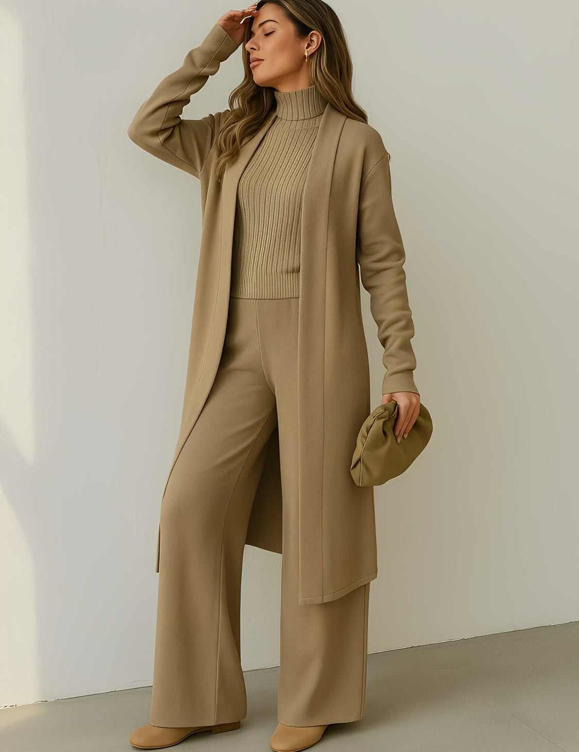 Modelo vestindo Trijunto Lolla bege estilo aerolook elegante, composto por calça pantalona fluida, regata de gola alta e cardigan alongado em viscose premium.