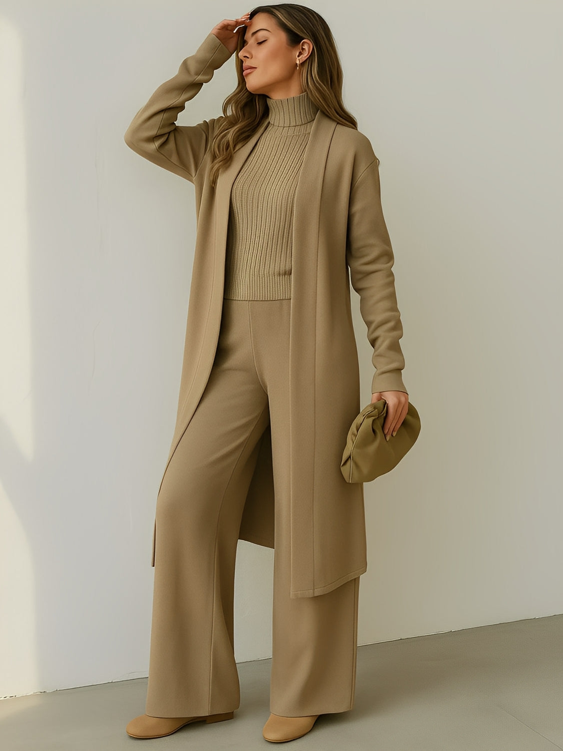 Modelo vestindo Trijunto Lolla bege estilo aerolook elegante, composto por calça pantalona fluida, regata de gola alta e cardigan alongado em viscose premium.