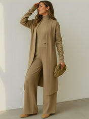 Modelo vestindo Trijunto Lolla bege estilo aerolook elegante, composto por calça pantalona fluida, regata de gola alta e cardigan alongado em viscose premium.