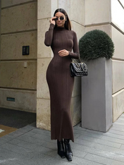 Modelo vestindo Vestido Amira marrom café, comprimento midi alongado, tecido canelado ajustado ao corpo, gola alta e mangas longas, estilo minimalista elegante.